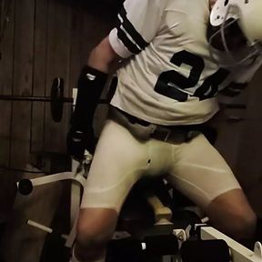 Football jock lifting weights with plug