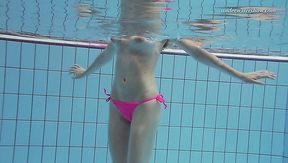 Hot redhead pale skin teen babe in pink bikini dives in the pool