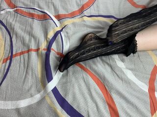 Caressing lengthy legs of angel in ebony lace socks