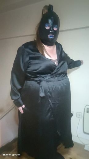 BBW TV poses in satiny black wrap dress.