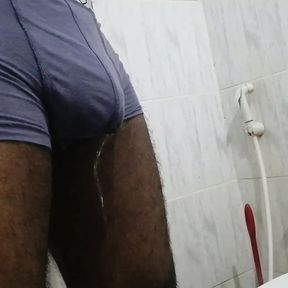 An Asian black boy pissing in his underwear