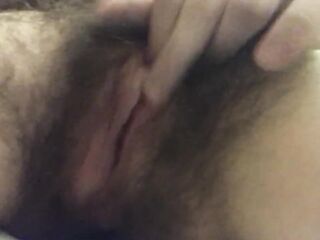 Hair twat masturbates up close