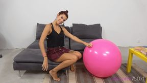 Cute girl Barbara inflates a large party balloon (MOBILE quality)
