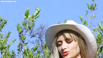 Slim, blonde teen is displaying her perfectly shaved pussy in the nature, during the day