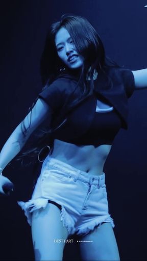Asian female in black tank top and denim shorts dancing on stage
