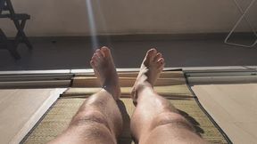 Sunbathing naked male legs.