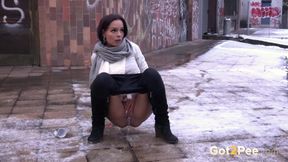 Hot brunette peeing in the street in cold winter season