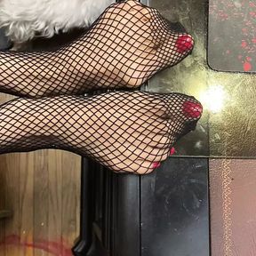 red nail polish tiny feet in fishnet stocking