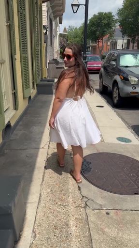 Blonde woman in white dress walking down street