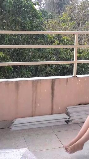 Cute lady is swinging on a hanging swing, hiding from the rain under an umbrella. 185 2   Clip 1