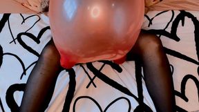 Empress Scarlett blows to pop a 30” mouse balloon