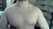 Muscular camboy flexes his muscles and squats