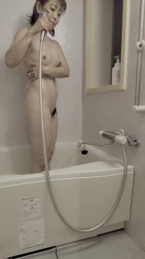 Asian mature woman takes a shower