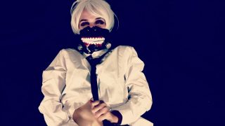 Kvinnlig Ken Kaneki-cosplayer som leker med sig själv