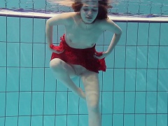 Red Dressed teen swimming with her eyes opened