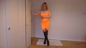 Foxy blonde in a tight orange dress, fishnets and latex boots