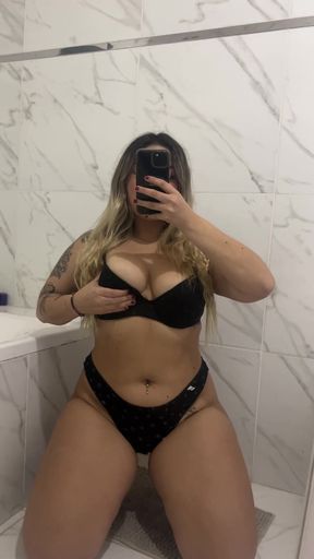 Curvy blonde babe sits and relaxes in bathroom stall solo
