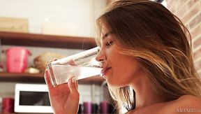 After drinking a glass of water naked babe flashes her alluring shaved pussy