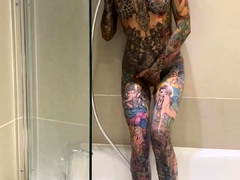 Tattooed beauty indulges in hot masturbation in the shower