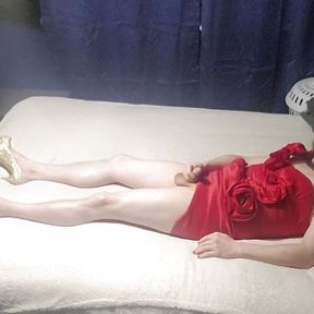 crossdresses layed on bed in little red dress