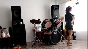 They play the drums for her - she dances, stripping and showing her ass