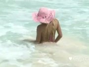 Karla Carrillo on the beach in a pink hat