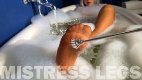 Scratching Mistress's nylon feet with a scratcher in a foam bath (MP4 4K)