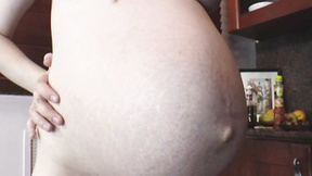 Preggo beauty poses naked in the kitchen
