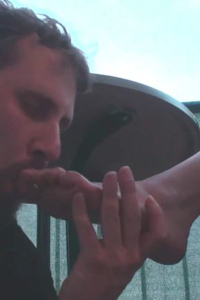Sexy femdom smoking a cigarette while getting feet licked and toes sucked
