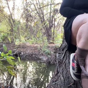 MILF in a short dress and pantyhose masturbates on the river bank