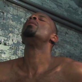 Two hot black men suck dick by a cement wall.