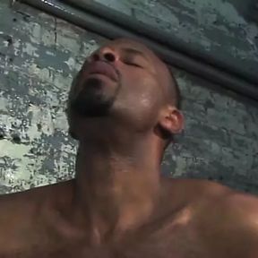 Two hot black men suck dick by a cement wall.