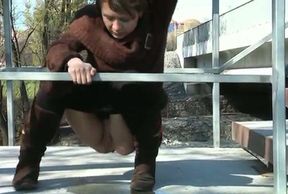 Nasty brunette chick pulls her pants off to pee on the stairs