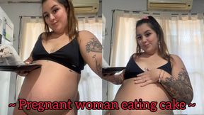 Pregnant woman eating cake + moving belly