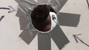 Bearded guy sucks a ebony shaft at a gloryhole