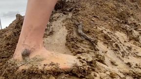 Bare feet caked with sticky mud on slippery hill