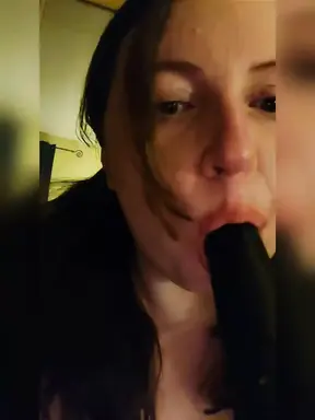 Sucking a big black dildo