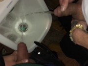 Boys piss and spit together at the urinal after some cocktails