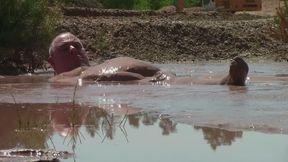 Deep, creamy brown mud bath in a sand pit