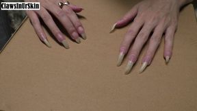 sharp nails scratching and piercing cardboard hard