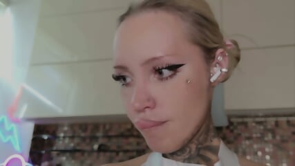 GORGEOUS TATTOED PLASTIC BLONDE BABE TEASES  LICKING A BIG DILDO DROWLING AND  FLASHING HWE BIG FAKE TITS WITH PIERCED NIPPLES
