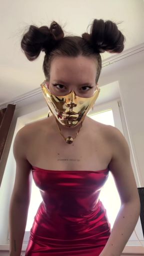 Sultry beauty in golden mask and metallic red dress
