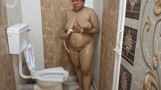 Gorgeous Indian aunty masterbating and pissing herself in bathroom .