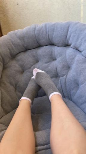 Feet in Grey Socks Playing with Tennis Ball