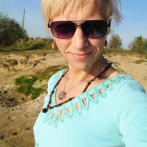 Trans girl swimming in the lake in clothes blue blouse and white-milk pants.