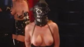 Sensuous dominatrix plays with toys on masked latex girl