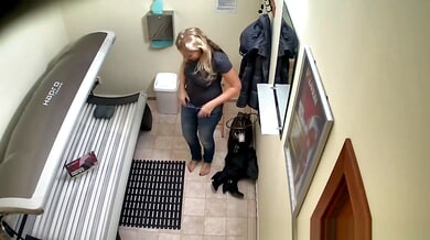 Blonde MILF prepares for a solarium session in her private hallway