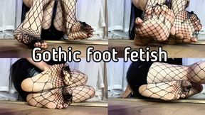 The feet of a gothic girl in large fishnet tights