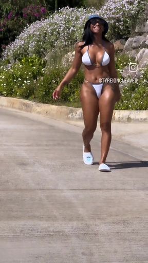 Blonde woman in bikini walking on sidewalk