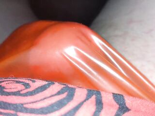 Masturbating in a red plastic strap